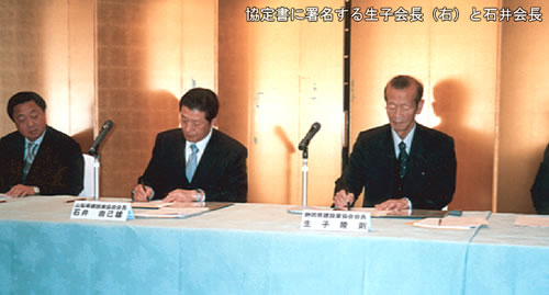 協定書に署名する生子会長（右）と石井会長